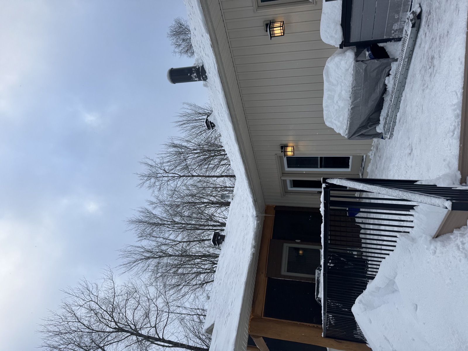 A cottage-style home with its roof fully cleared of snow in the evening light